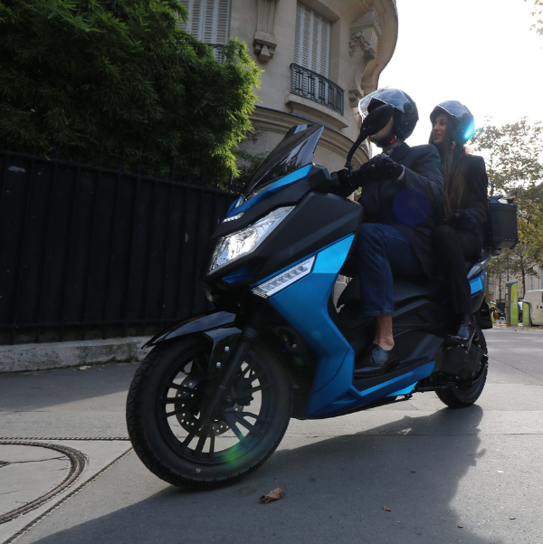 Scène de vie montrant le scooter électrique Pink Fly Phase 3 utilisé au quotidien en environnement urbain.