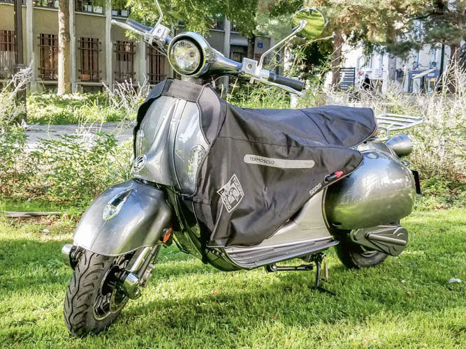 Tablier TERMOSCUD R013X utilisé sur scooter électrique, idéal pour les trajets urbains hivernaux en toute protection.